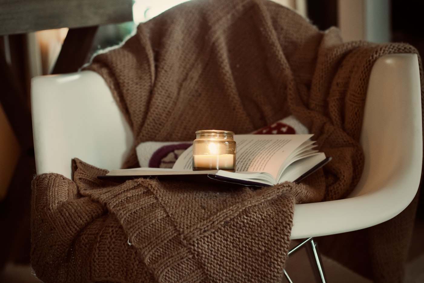 Kerze und Buch auf einem Stuhl im warmen Licht