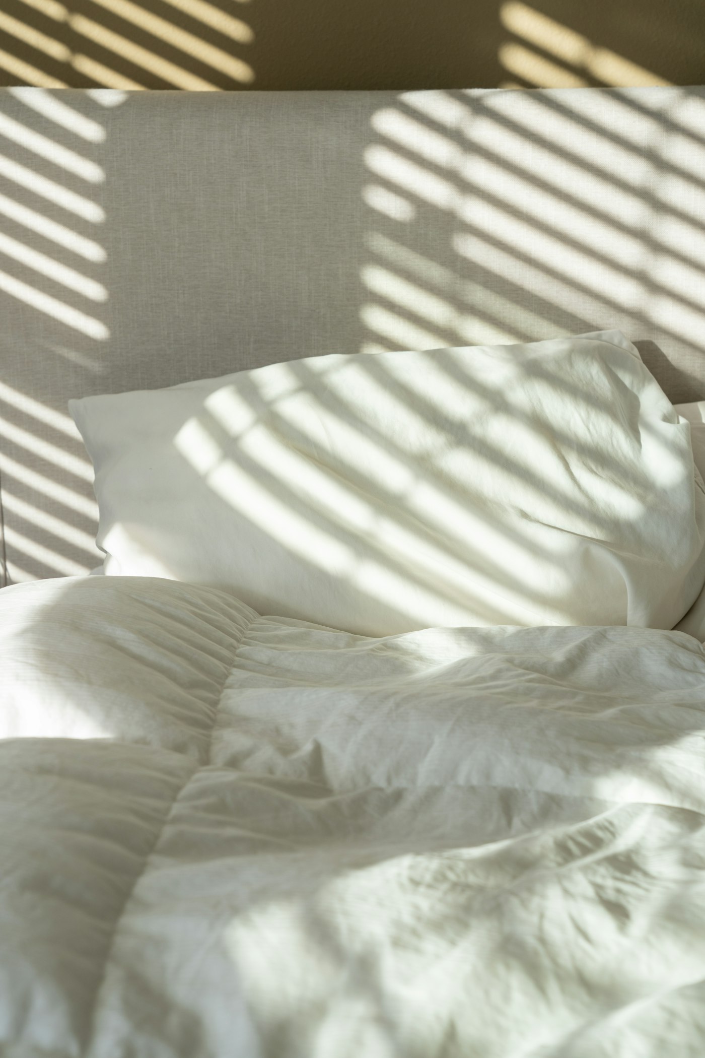 Frisch bezogenes Bett mit weißer Bettwäsche